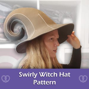 Puede incluir: Un sombrero de color tostado con ala ancha y una corona alta en espiral similar a un cuerno. El sombrero presenta detalles de líneas blancas a lo largo de las costuras y una parte inferior oscura. El texto "Swirly Witch Hat Pattern" está impreso en blanco.