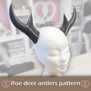 May include: A white foam mannequin head wearing a pair of black, curved, branched antlers. The antlers feature visible white printed lines and numerical markings across their surface. The text "Roe deer antlers pattern" is displayed below.