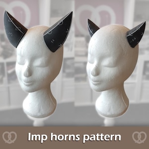 May include: A pair of black imp horns featuring white geometric symbols and numbers printed on the surface. The horns are displayed on a white mannequin head. The text "Imp horns pattern" is visible at the bottom of the image.