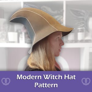 Può includere: Un cappello da strega color marrone chiaro e grigio con una corona curva e appuntita e una tesa larga e svasata. Il cappello presenta linee di cucitura visibili lungo la struttura. Sotto il cappello, un banner viola mostra il testo bianco Modern Witch Hat Pattern.