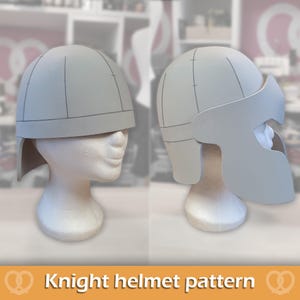 May include: A light grey foam knight helmet pattern displayed on two white mannequin heads. The left view shows the rounded dome and base, while the right view features the extended face guard and side panels with visible construction lines.