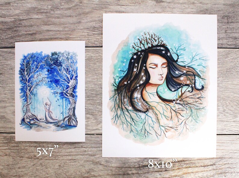 May include: Two watercolor paintings on white paper. The first painting is 5x7 inches and depicts a figure in a white dress standing in a blue and white forest. The second painting is 8x10 inches and depicts a woman with long brown hair and a crown of branches, surrounded by blue and white branches.