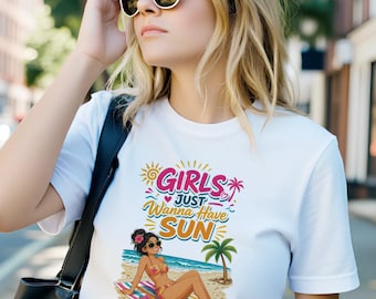 May include: A white short-sleeved t-shirt featuring a colorful graphic print of a person lounging on a beach towel under a palm tree. The text reads Girls Just Wanna Have Sun. The design includes a sun, hearts, and tropical flowers.