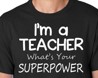 May include: Black t-shirt with white text that reads "I'm a TEACHER What's Your SUPERPOWER"