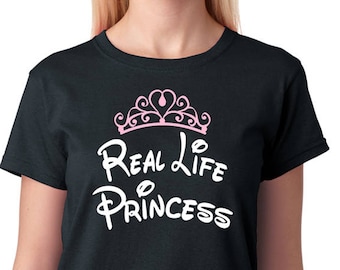May include: Black t-shirt with a pink crown and the text "Real Life Princess" in a white Disney font.