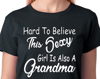 May include: Black t-shirt with white text that reads "Hard To Believe This Sexy Girl Is Also A Grandma".