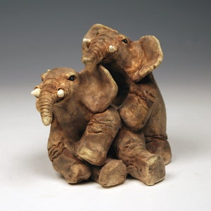 Two playful ceramic elephants sculpture, intricate handmade small elephant sculpture