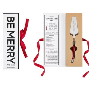 May include: A red and white gift box with a pie server inside. The box has a white label with the text "HOLIDAY STARBAKER" and a recipe for "HOLIDAY APPLE PIE". The pie server has a red handle and the text "I Love You Best Baker 2023".