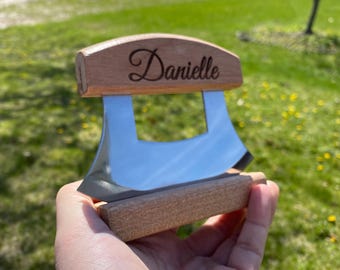 May include: A personalized wooden cheese knife with a stainless steel blade. The handle is engraved with the name "Danielle".