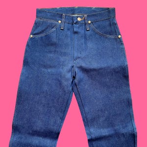 Op de afbeelding: Een blauwe spijkerbroek met een klassiek ontwerp met vijf zakken. De jeans heeft een knoop- en ritssluiting, samen met goudkleurige klinknagels en een knoop. De jeans is gemaakt van een stevige denim stof.