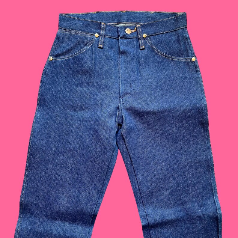 Op de afbeelding: Een blauwe spijkerbroek met een klassiek ontwerp met vijf zakken. De jeans heeft een knoop- en ritssluiting, samen met goudkleurige klinknagels en een knoop. De jeans is gemaakt van een stevige denim stof.