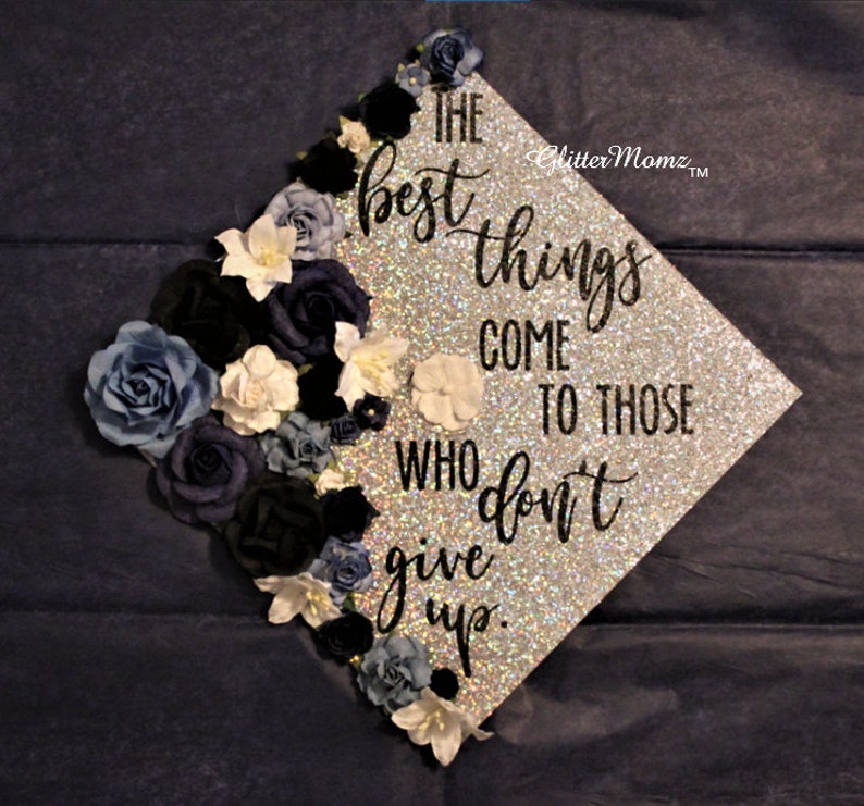 May include: A silver glitter graduation cap decorated with blue and white flowers and the quote "The best things come to those who don't give up."