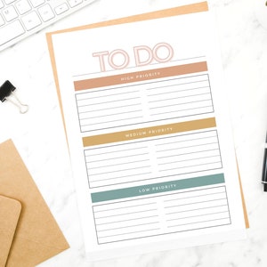 May include: A printable to-do list with three sections: high priority, medium priority, and low priority. Each section has a coloured header and lined spaces for writing tasks.