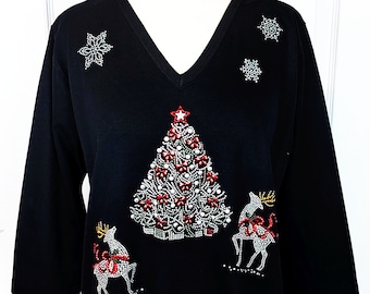 Puede incluir: Camiseta negra de manga larga con un diseño de árbol de Navidad con cuentas, dos renos y copos de nieve.