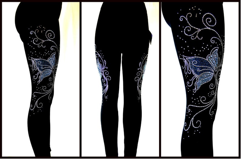 May include: Black leggings with a blue and silver butterfly design made of rhinestones. The butterfly design is on the side of the leg and has a floral pattern.