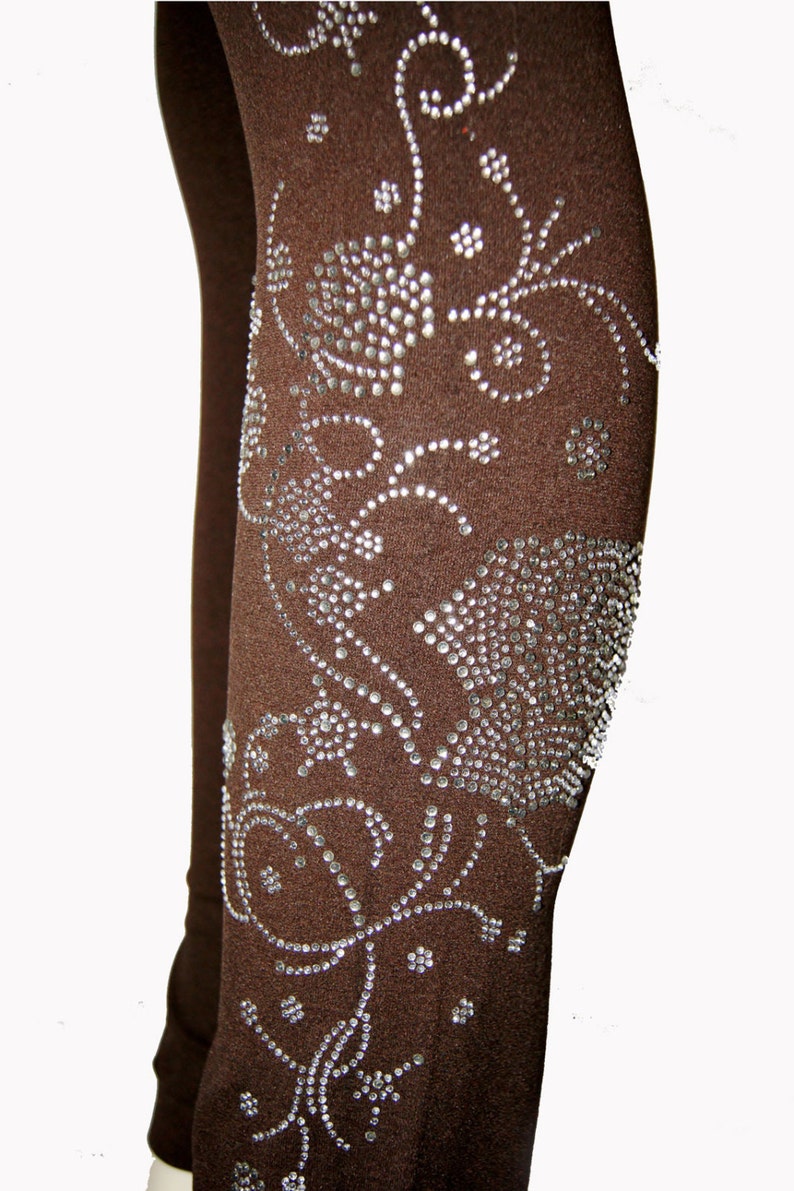 May include: Brown leggings with a silver rhinestone floral design.