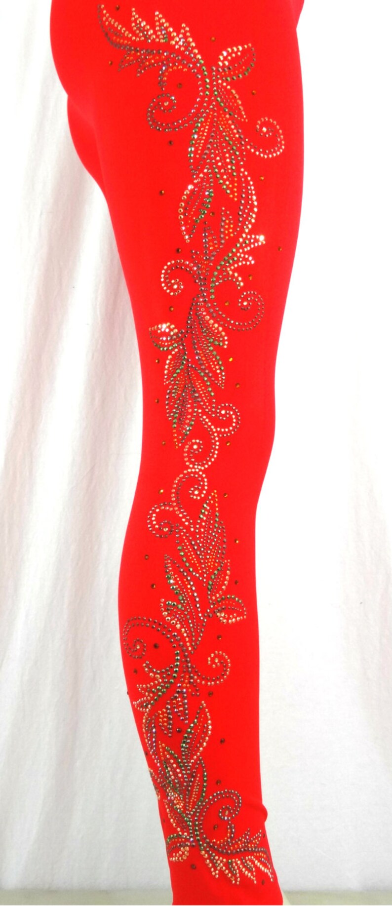Puede incluir: Leggins rojos con un dise&ntilde;o floral de pedrer&iacute;a en el lateral.