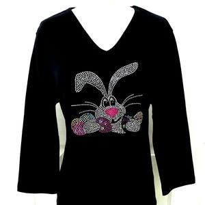 May include: Black long-sleeved shirt with a rhinestone bunny rabbit design holding colorful Easter eggs.