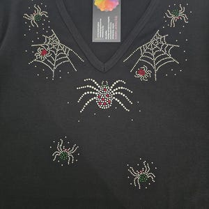 Peut inclure: T-shirt noir &agrave; col en V orn&eacute; de motifs d'araign&eacute;es et de toiles d'araign&eacute;es en strass. Les araign&eacute;es ont des accents rouges et verts. Une &eacute;tiquette avec un logo color&eacute; est attach&eacute;e &agrave; l'encolure. V&ecirc;tement sur le th&egrave;me d'Halloween ou gothique.