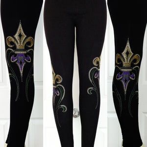 May include: Black leggings with a gold, purple, and green fleur-de-lis design on the legs.