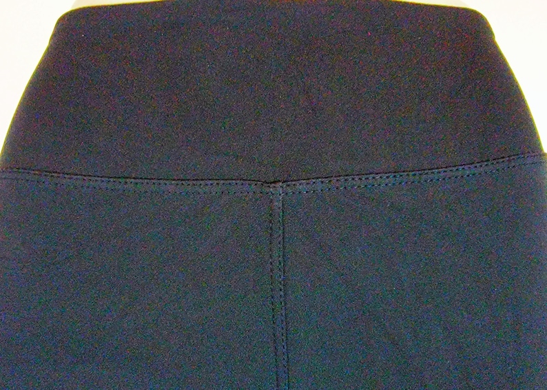 May include: Black leggings with a high waistband and a seam down the center of the front.