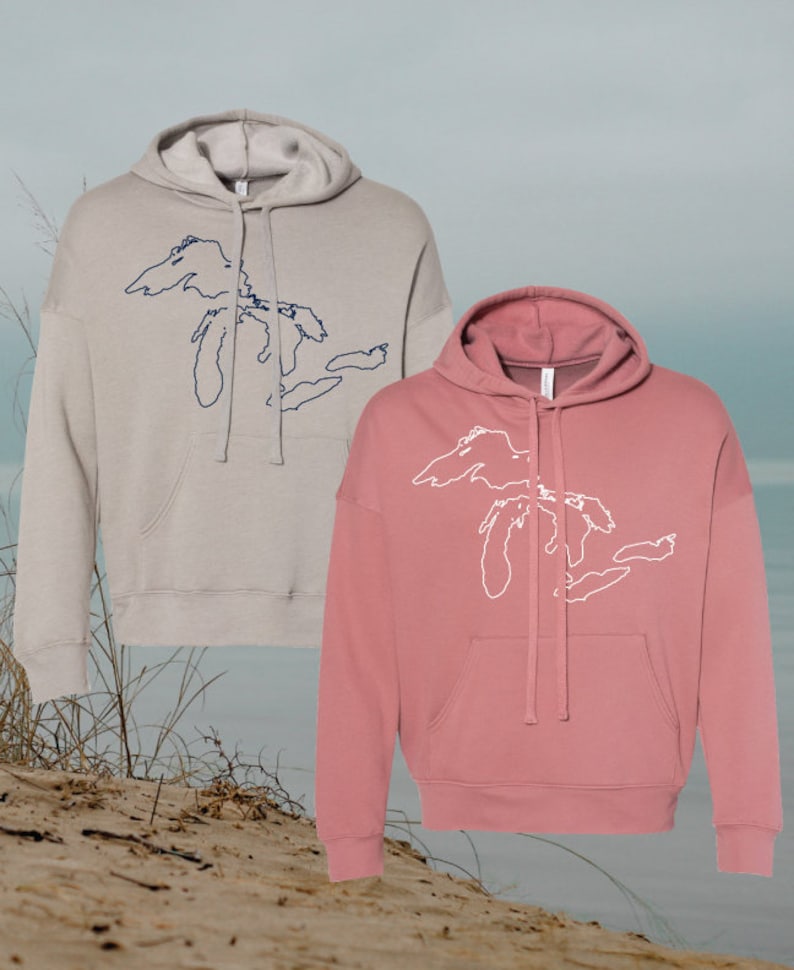 May include: Two hooded sweatshirts with a graphic of the Great Lakes on the front. One sweatshirt is light gray with a navy blue graphic, and the other is a dusty rose color with a white graphic.