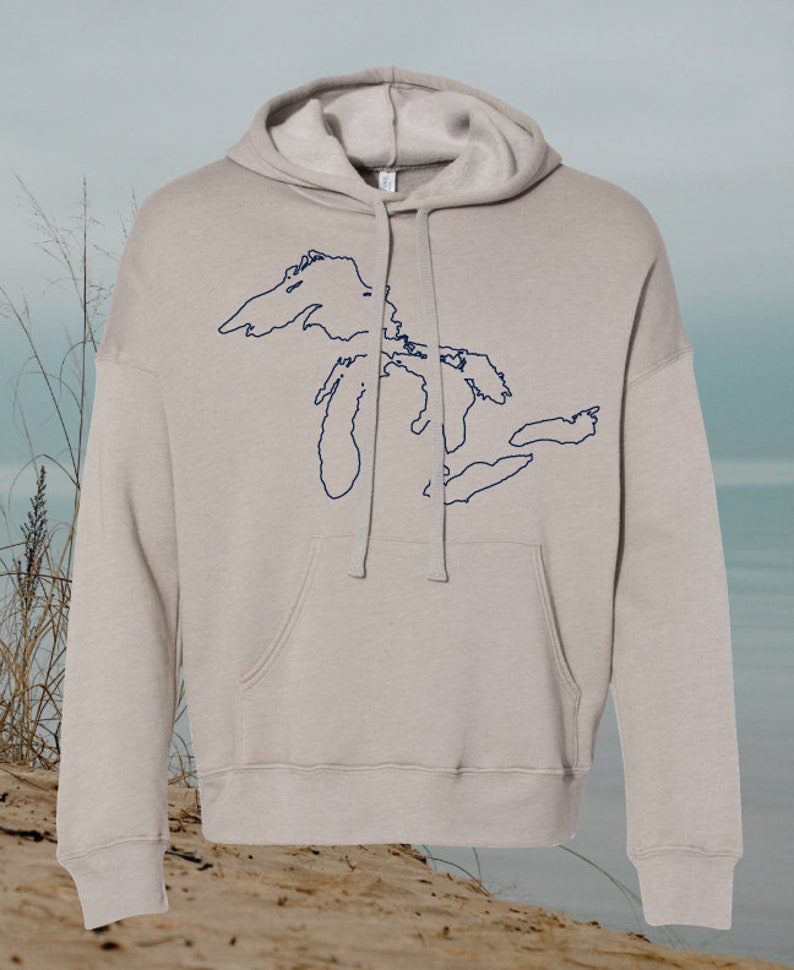 May include: A light gray hooded sweatshirt with a navy blue outline of the Great Lakes on the front.