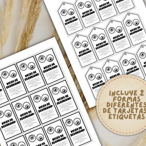May include: Black and white printed cards and tags with cartoon eyes and the text "AVISO DE SEGURIDAD" in Spanish. The image includes a circular label with the text "INCLUYE 2 FORMAS DIFERENTES DE TARJETAS/ ETIQUETAS".