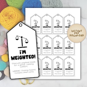 Puede incluir: Etiquetas blancas con el texto "I'M WEIGHTED!" y un gráfico de balanza. El texto "Lleno de cuentas con peso para una comodidad suave y calmante" y una advertencia de peligro de asfixia también están presentes.