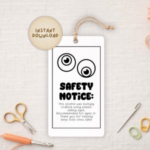Può includere: Un'etichetta bianca con la scritta "SAFETY NOTICE" e occhi dei cartoni animati. L'etichetta include anche il testo "This plushie was lovingly crafted using plastic safety eyes. Recommended for ages 3+". Sono visibili forbici dorate e altri materiali per l'artigianato.