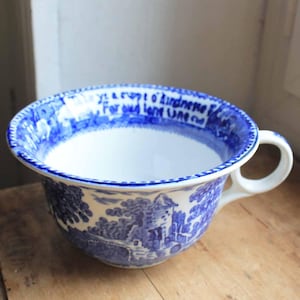 May include: A white ceramic mug with a black handle and the text "But First, Coffee" in a handwritten style. The mug is on a white surface. The mug is approximately 4 inches tall.