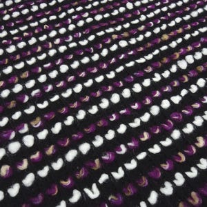 May include: A close-up of a black fabric with a textured pattern of white and purple loops. The fabric has a soft, fuzzy texture.