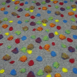 Peut inclure: Tissu de feutre gris orné de points colorés, texturés et en relief. Les points sont dans des tons de rouge, orange, jaune, vert, bleu et violet. Le tissu a un aspect doux et fait à la main.