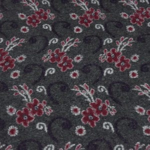 Könnte beinhalten: Ein dunkelgrauer Stoff mit einem sich wiederholenden Muster aus tiefroten Blumen mit weißen Zentren und zarten weißen Stielen. Das Design enthält dunkle, geschwungene, rankenartige Akzente, die sich zwischen den Blumenclustern verteilen.