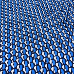 May include: A fabric featuring a repeating geometric pattern of vertical columns. Each column consists of alternating blue and white semi-circular shapes arranged against a dark navy blue background, creating a structured and rhythmic visual effect.