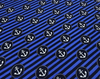 Puede incluir: Tela a rayas azules y negras con un patrón repetido de símbolos de anclas blancas dentro de círculos. Las anclas están delineadas en negro.