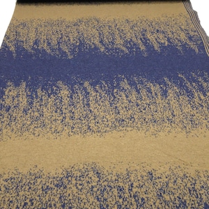 Könnte beinhalten: Ein Stoffmuster mit einem Farbverlaufsmuster in Blau und Braun. Der Stoff hat eine strukturierte, gesprenkelte Optik.