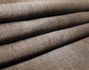 May include: Close-up of a brown fabric with a textured weave. The fabric is folded in layers, creating a soft and inviting look.