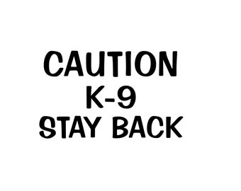 May include: Black and white sign with the text "CAUTION K-9 STAY BACK".