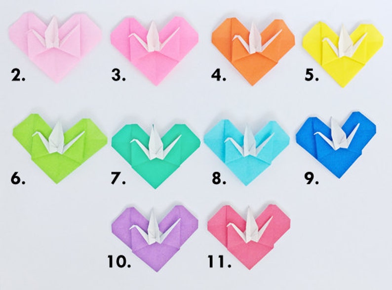 May include: A collection of eleven origami hearts in various colors, each with a white origami crane in the center. The hearts are numbered 2 through 11, and include pink, orange, yellow, green, blue, and purple.