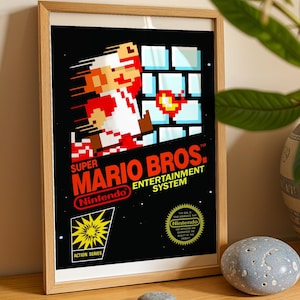 May include: A framed poster featuring the Super Mario Bros. Entertainment System box art. The design includes a pixelated Mario character, a blue brick wall, the Nintendo logo, and an Action Series emblem on a black background with white stars.