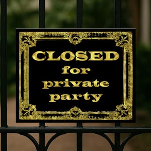 Könnte beinhalten: Ein schwarzes Schild mit goldfarbenen Buchstaben und einem dekorativen Goldrand mit der Aufschrift „GESCHLOSSEN für private Feier“. Das Schild ist an einem schwarzen Metalltor angebracht. Der Hintergrund ist unscharf, was auf eine Umgebung im Freien hindeutet.