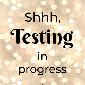 Pu&ograve; includere: Un cartello rettangolare con il testo nero Shhh, Testing in progress centrato su uno sfondo di luci bokeh circolari sfocate nei toni del beige e del bianco. Il testo &egrave; incorniciato da due sottili linee orizzontali nere con piccoli rombi.