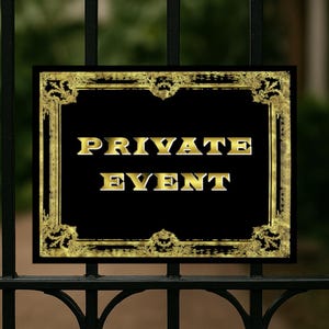 May include: A rectangular sign with a black background and gold lettering that reads PRIVATE EVENT. The sign features an ornate, distressed gold border with intricate scrollwork patterns, mounted on a black metal gate with vertical bars.