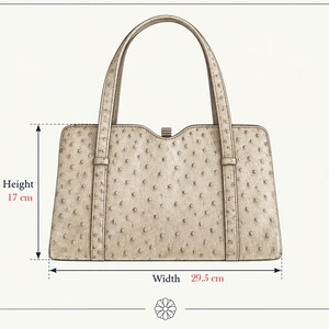 May include: A beige handbag with a textured, dotted surface pattern, two top handles, and a central clasp. The bag measures 17 cm in height and 29.5 cm in width as indicated by the text and arrows on the image, providing clear dimensions.