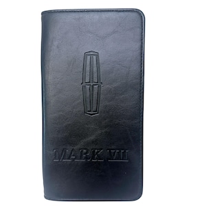 May include: A black rectangular wallet featuring a smooth, slightly textured surface. The front displays an embossed Lincoln logo centered near the top, with the text MARK VII embossed in a bold, capitalized font positioned towards the bottom.