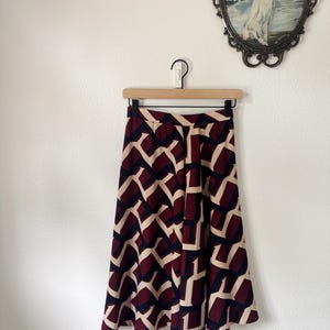 A very cool  vintage skirt, with nice geometic design, dark blues, burgundy and cream colors, side zipper.