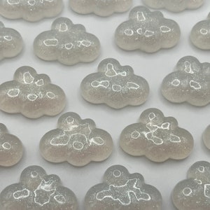 May include: A collection of white glitter cloud shaped resin embellishments.