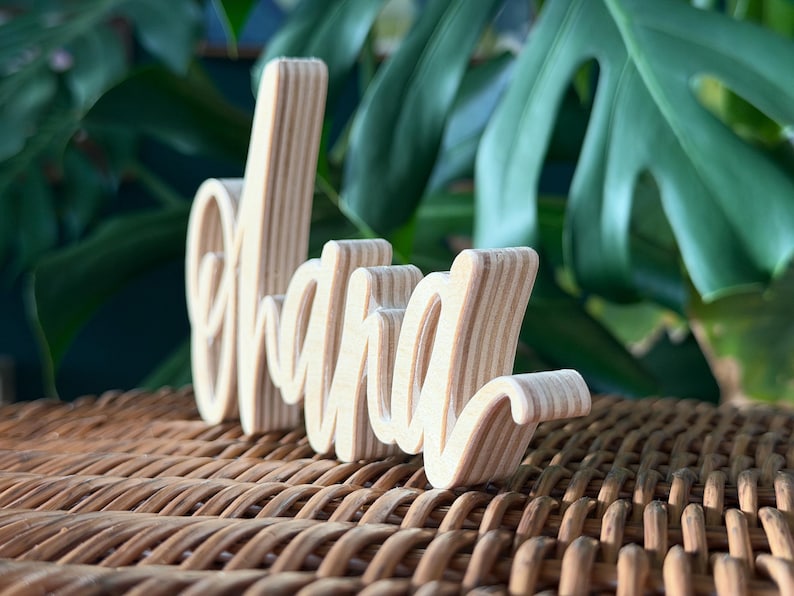 May include: A handmade wooden sign with the text "Welcome" in a playful font. The sign is painted white with a distressed finish, and features a small, decorative heart. Dimensions are approximately 12 inches wide and 6 inches tall.