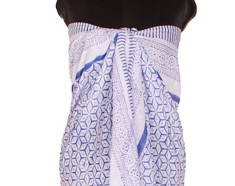May include: A sarong featuring a white base with a blue geometric pattern of repeating cubes and circular floral motifs. The fabric is draped around a mannequin, displaying a vertical orientation with a central fold and a repeating print design.